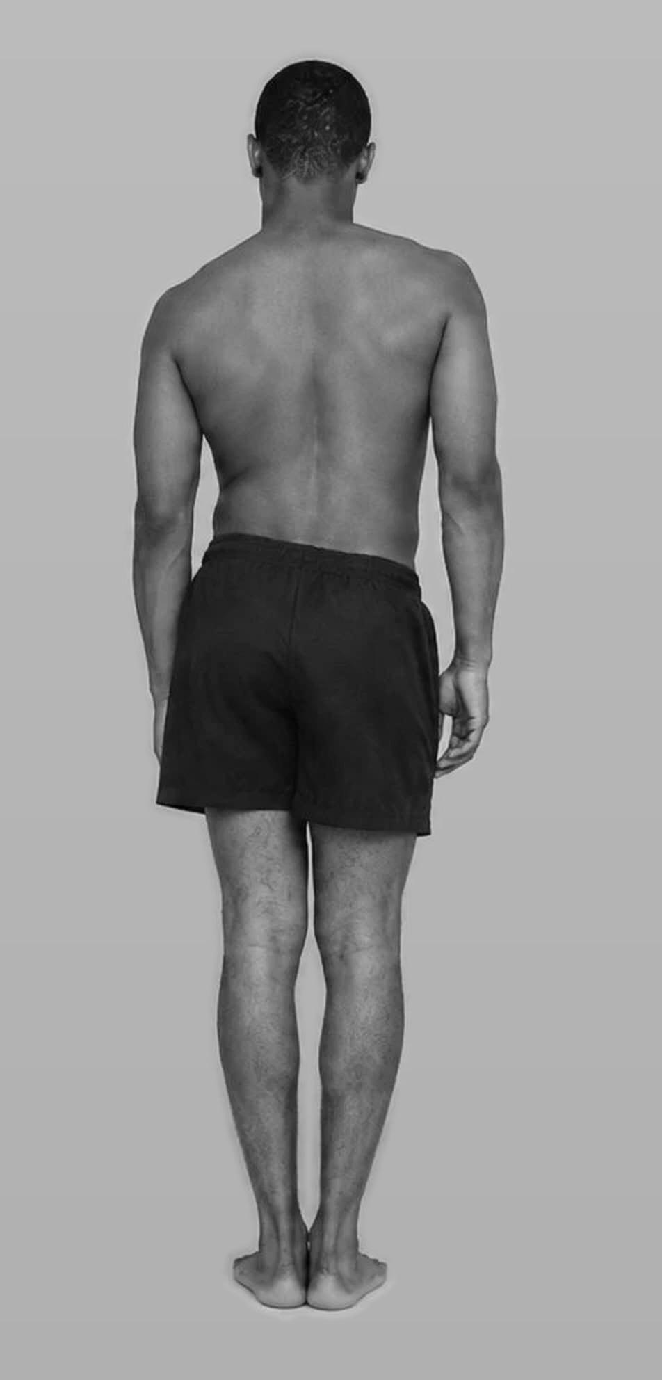 A man standing, seen from behind, back and shoulders